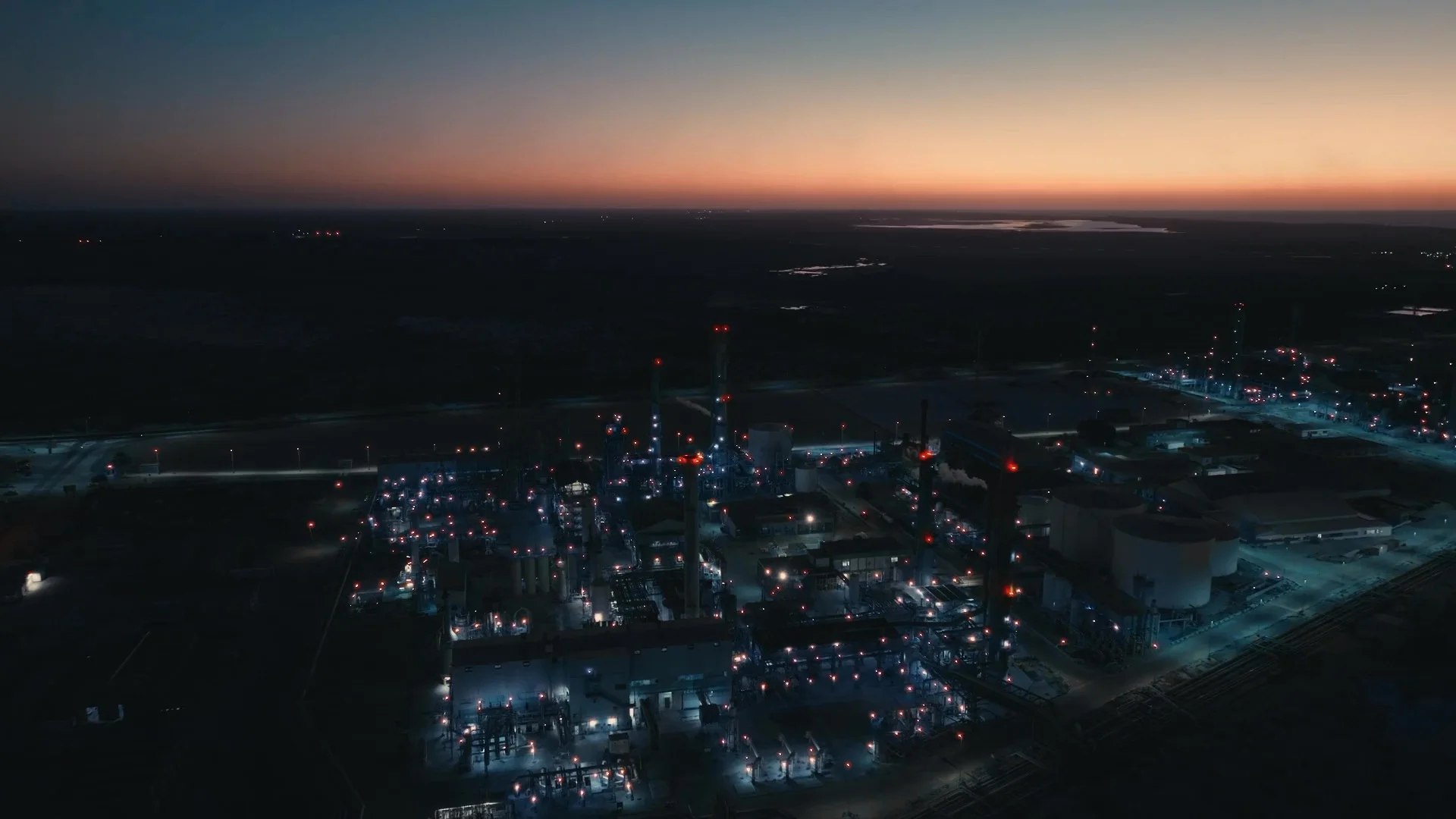 Aerial view of an industrial complex illuminated at dusk